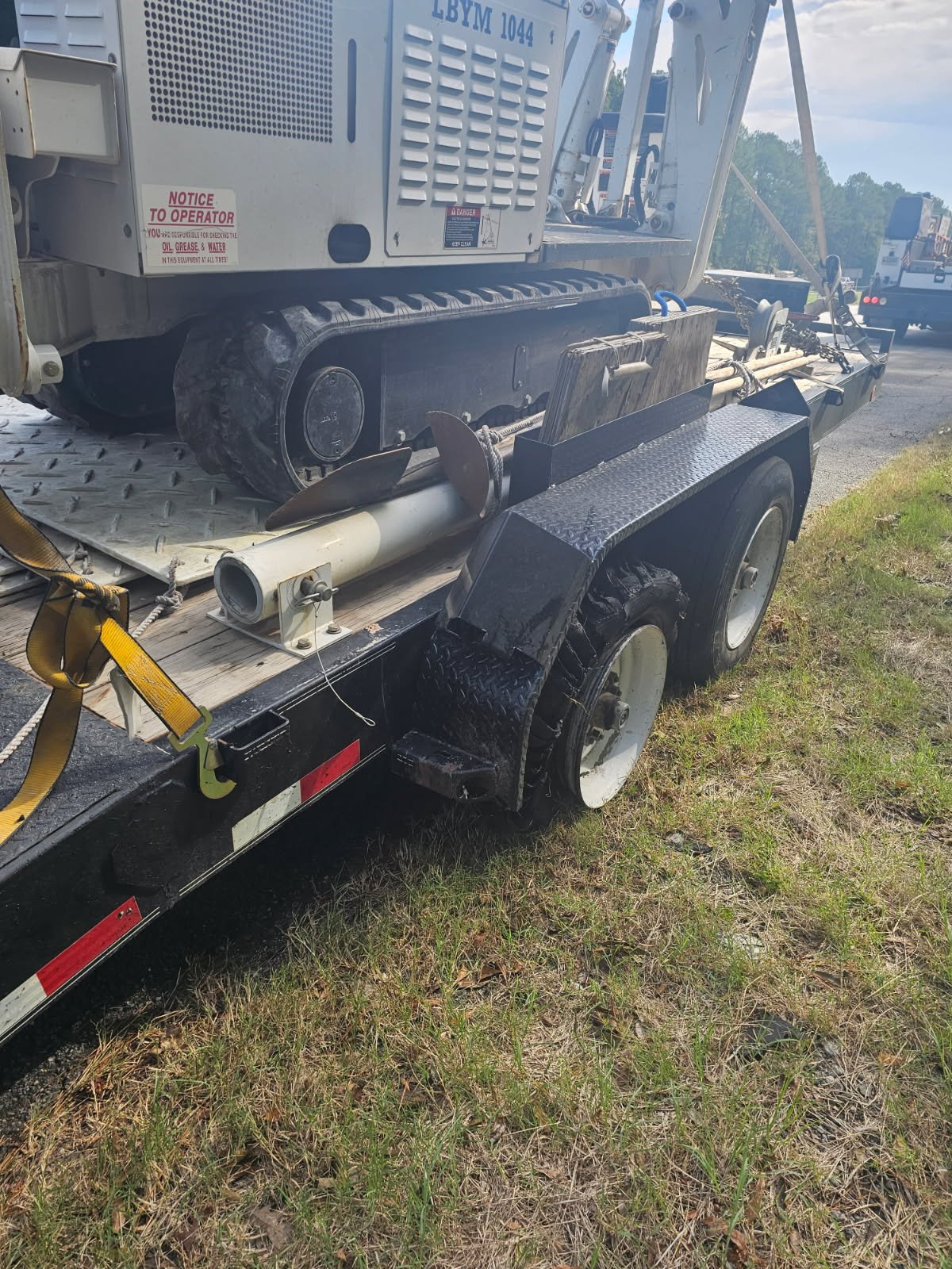 Equipment trailer receiving emergency roadside tire replacement in Greensboro, Georgia.