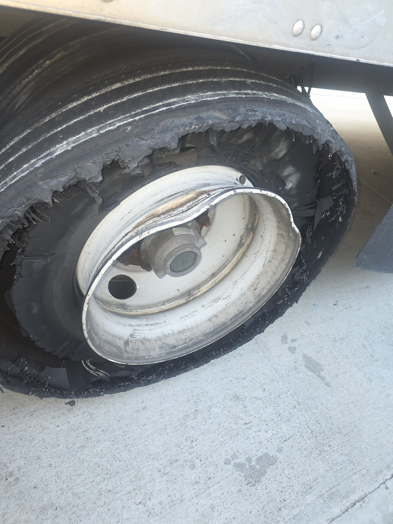 Damaged trailer wheel and tire from a roadside blowout job in Norwood, Georgia.